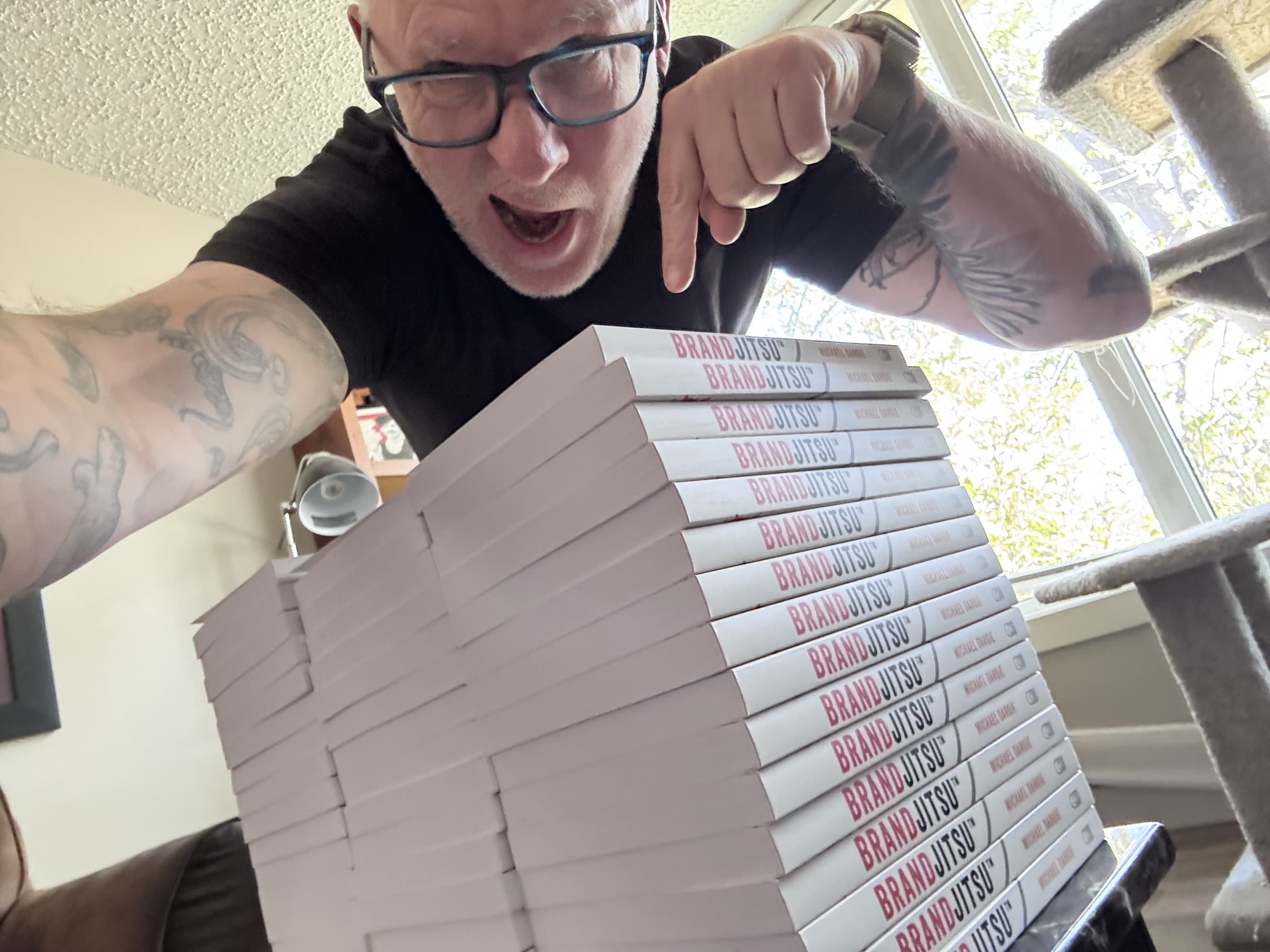 Michael Dargie pointing at a stack of BrandJitsu™ books