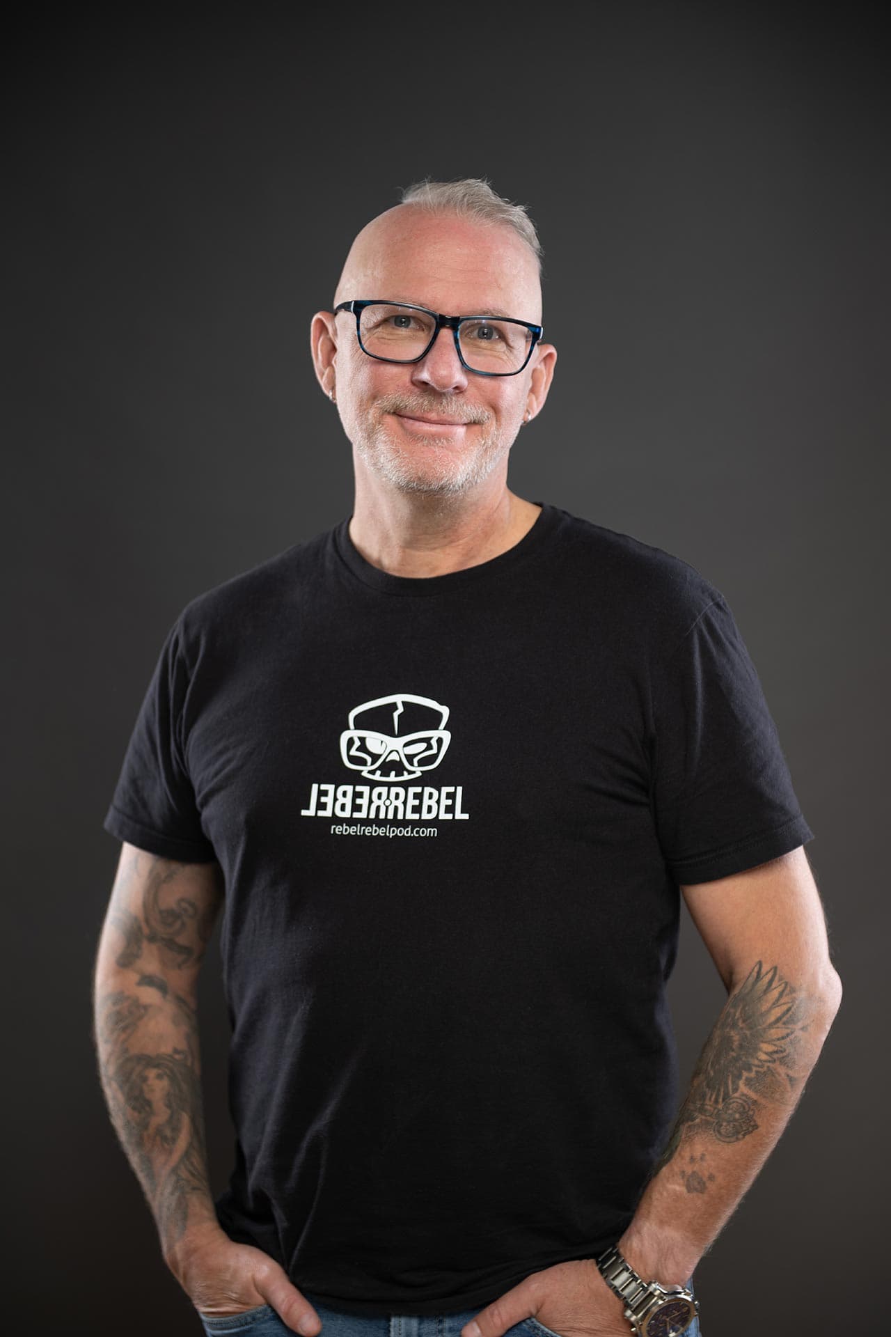 Michael Dargie in a black RebelRebel t-shirt, hands in pockets, smiling