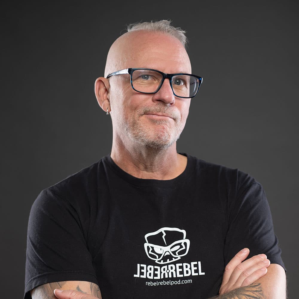 Michael Dargie in a black RebelRebel t-shirt, arms crossed, square framing