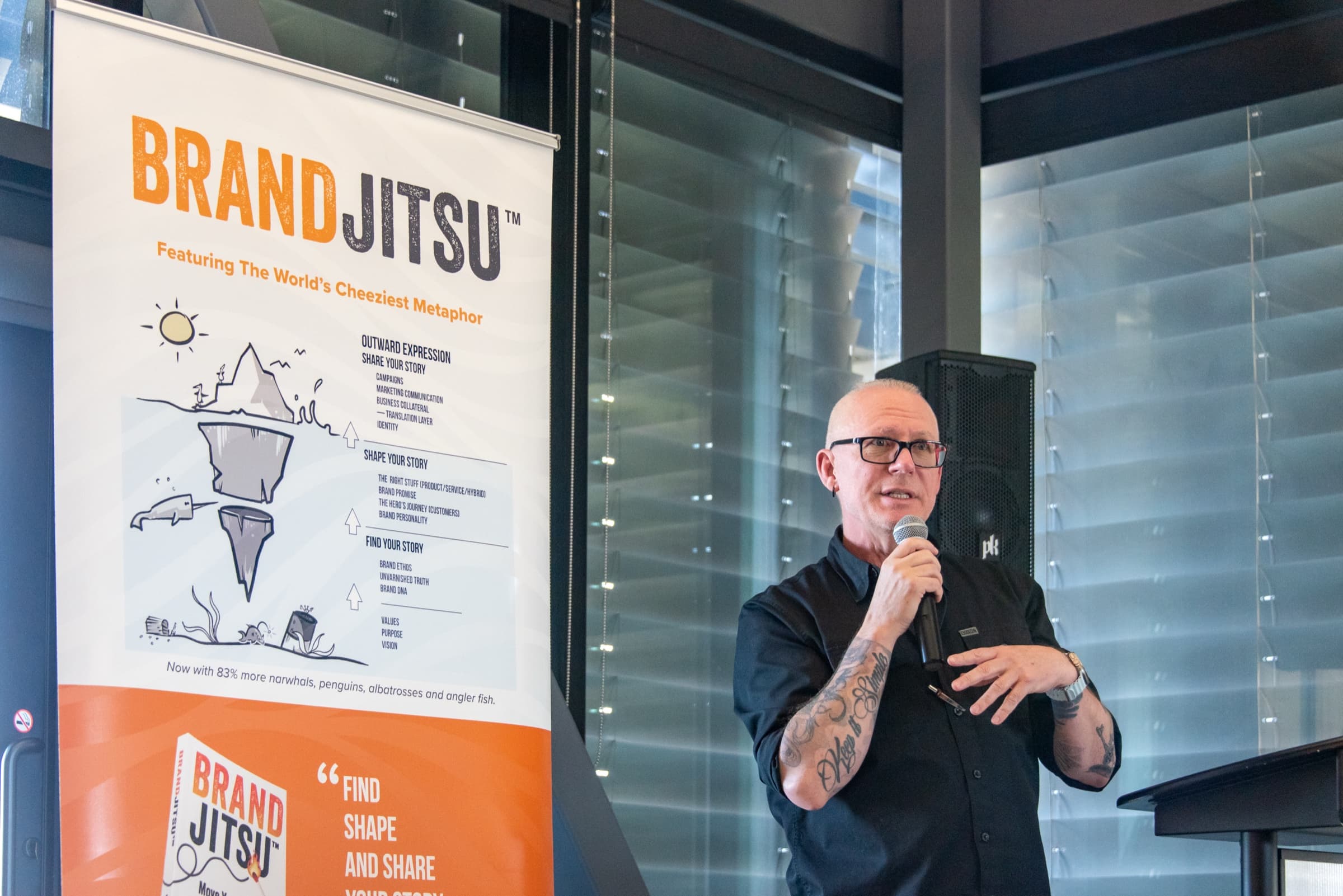Michael Dargie speaking on stage with the BrandJitsu™ banner