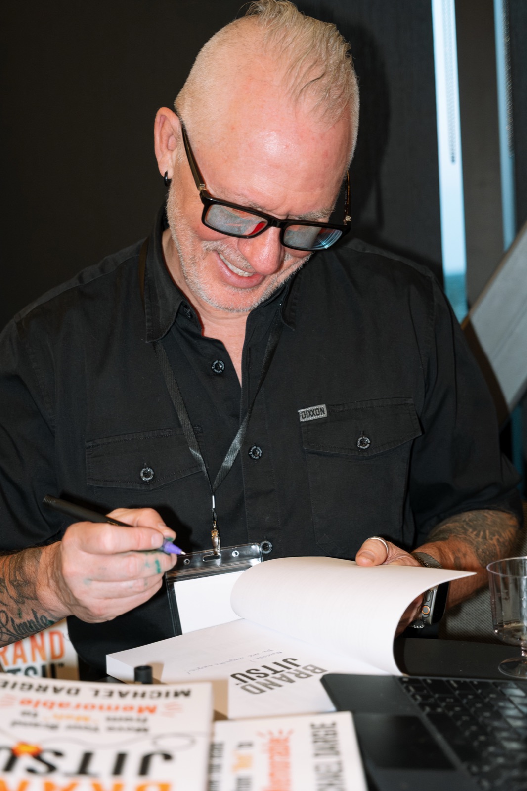 Michael Dargie smiling while signing a copy of BrandJitsu