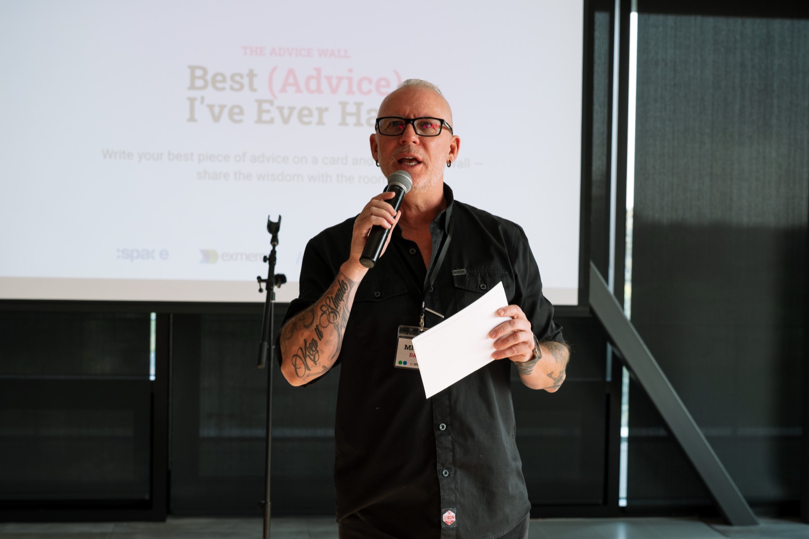 Michael Dargie speaking with a microphone in front of a slide reading Best Advice I've Ever Had